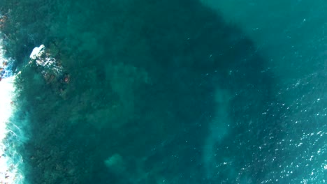 Aerial-birdseye-flying-over-Pacific-waters-heading-towards-Waimea-Beach,-Hawaii