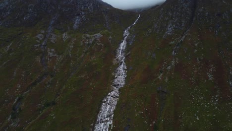 Slow-motion-drone-landscape-of-Ben-Nevis-Waterfall-geological-formation-water-stream-fall-through-wet-humid-mountain
