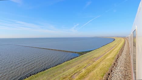 Train-running-along-the-Hindenburg-dam-in-Sylt-Westerland-in-a-sunny-day