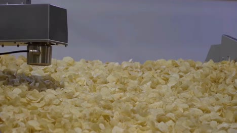 Close-up-shot-chips-are-fried-are-moving-on-a-conveyor