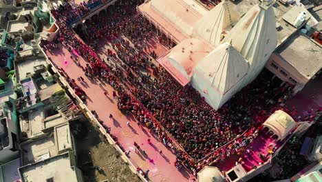 Aerial-drone-view-top-down-shot-is-moving-forward-and-many-people-are-playing-dhule-with-many-people-watching-from-above