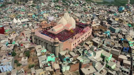 Vista-Aérea-De-Drones,-La-Cámara-De-Drones-Avanza-Donde-Se-Ve-Un-Gran-Templo-Entre-Las-Casas-Alrededor,-Hay-Muchas-Personas-Jugando-Juntas