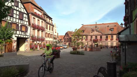 Dos-Ciclistas-Franceses-Recorren-La-Encantadora-Ciudad-De-Bergheim,-En-El-Este-De-Francia.