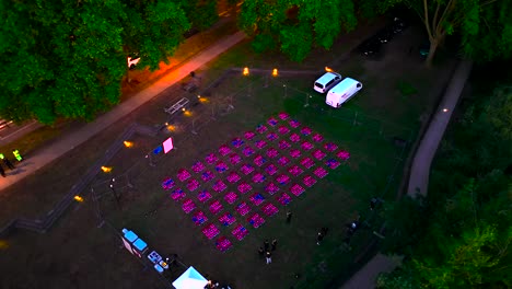 Drone-lights-being-tested-before-display-show-by-technicians-at-Wine-Fair,-Aerial-pan-right-shot