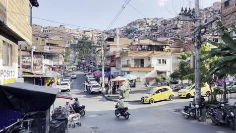 Street-car-view-driving-inside-comuna-13-medellin-colombia-vibrant-latin-town-life-daily-stores-markets-pedestrians-and-motorcycles