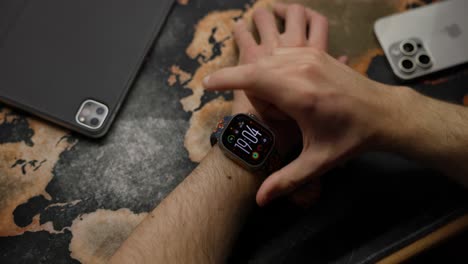 Mann-Benutzt-Smartwatch-An-Einem-Tisch---Aufnahme-Aus-Großer-Perspektive