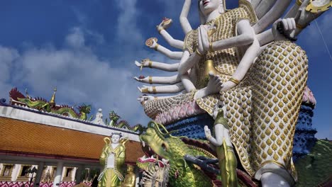 Cielos-Azules-Sobre-El-Templo-Wat-Plai-Laem-Con-La-Estatua-De-Guanyin-Con-Muchos-Brazos-En-Koh-Samui,-Tailandia,-Vibrante-Arte-Religioso