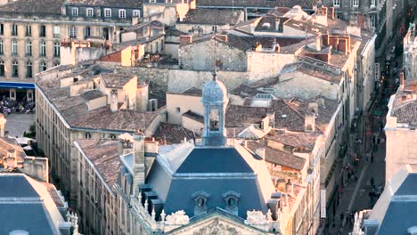 Dome-observation-tower-at-Gabriel-Bistrot-restaurant-at-Place-de-la-Bourse-plaza-square-with-city-behind,-Aerial-tilt-up-reveal-shot