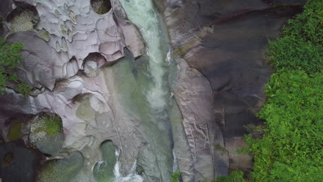 Una-Pausada-Perspectiva-Aérea-Captura-Las-Rocas-De-Babinda-En-Cairns,-Australia,-Mostrando-Las-Rápidas-Corrientes-Que-Atraviesan-Sus-Formaciones-De-Granito,-Envueltas-Por-Un-Exuberante-Follaje-Verde.