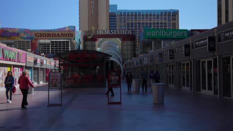 Tourists-walk-along-outdoor-shopping-mall-in-downtown-Las-Vegas-on-sunny-day