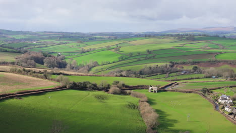 Cornworthy-Priory-old-ruin-nestled-on-rolling-hill-lush-landscape,-Devon,-UK