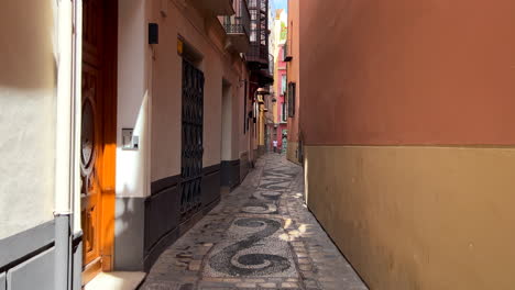 Walking-through-a-tight-small-historical-street-in-Malaga-city-center,-beautiful-old-architecture-in-Spain,-popular-vacation-holiday-destination,-4K-shot