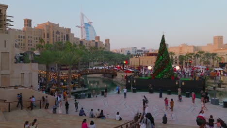 Dubai,-Emiratos-Árabes-Unidos---26-De-Diciembre-De-2023:-Turistas-Que-Disfrutan-De-Su-Tiempo-Alrededor-De-Un-árbol-De-Navidad-En-El-Zoco-Madinat-Jumeirah-En-Dubai
