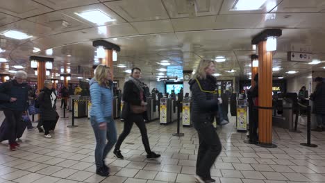 People-are-passing-through-the-contactless-ticket-barriers-at-Piccadilly-Circus-Train-station-in-London,-England,-the-concept-of-urban-mobility-and-transit-efficiency