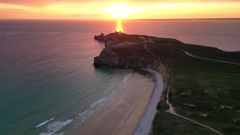 Wide-Lateral-Aerial-View-of-Rocky-Coastline-and-Beach-at-Sunset