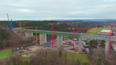 Cars-Driving-Through-The-Old-Aurach-Bridge-Next-To-The-New-Bridge-Under-Construction-In-Regau,-Austria