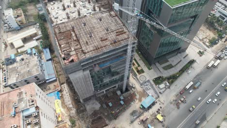 aerial-footage-of-a-tall-crane-in-operation-during-the-construction-of-a-high-rise-building