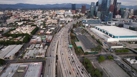 Aerial-View-of-Traffic-on-CA-110-Highway,-Harbor-Freeway-by-Downtown-Los-Angeles-and-Convention-Center