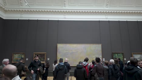 Los-Visitantes-De-La-Galería-Pasean-Por-La-Sala-41-De-La-Galería-Nacional-De-Retratos-De-Londres,-Admirando-Los-&quot;nenúfares&quot;-De-Claude-Monet-Y-Otras-Obras-De-Arte,-El-Concepto-De-Expresión-Cultural-Y-Artística.