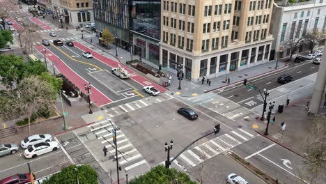 Aerial-view-of-a-busy-Oakland-intersection-with-traffic-waiting-for-a-signal-and-crossing