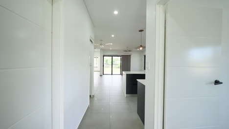 Dolly-along-hallway-to-Newly-Built-Minimal-Empty-Open-Plan-Kitchen-Dining-and-Lounge