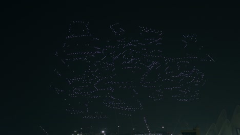 Espectáculo-De-Drones-En-El-Oscuro-Cielo-Nocturno-Sobre-La-Ciudad-Formando-Objetos-Geométricos,-Abu-Dhabi,-Emiratos-Árabes-Unidos