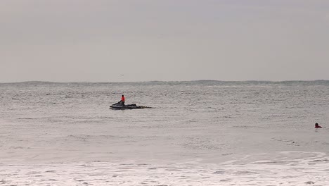 Panoramablick-Auf-Das-Meer-Mit-Jetski-Und-Surfer,-Die-Auf-Wellen-Warten