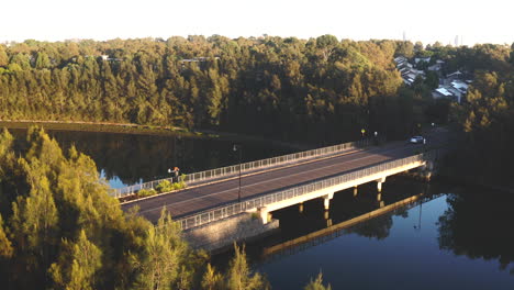 A-white-car-drives-over-an-empty-bridge-in-the-morning-in-the-suburb-of-Newington,-Sydney-Australia