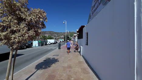 Walking-along-the-sunny-street-in-Malaga,-Spain