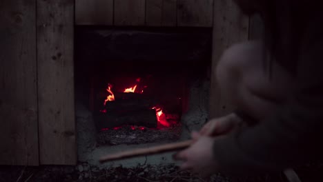 Man-Putting-Firewood-On-Fire-Under-Hot-Tub