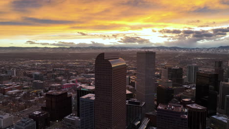 Wells-Fargo-Center-on-Denver-skyline,-snowy-Front-Range-in-back