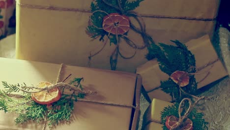 Arranging-gift-boxes-wrapped-and-decorated-with-paper,-twine-and-dried-fruit-and-pine-showing-zero-waste-and-sustainable-lifestyle