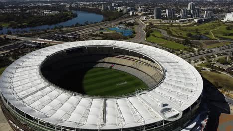 Aerial-drone-shot-high-above-Optus-Stadium-AFL-Football-Stadium-looking-into-ground-in-Perth,-Western-Australia-by-the-Swan-River