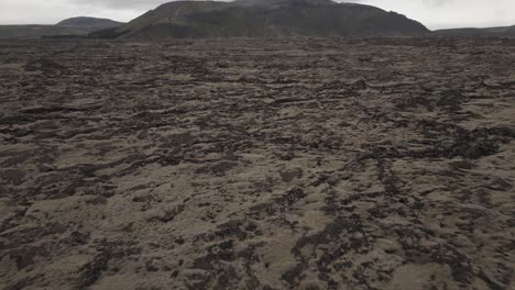 Paisaje-Panorámico-Con-Campos-De-Lava-En-Islandia-En-Un-Día-Sombrío,-Inclinación-Aérea-Hacia-Arriba