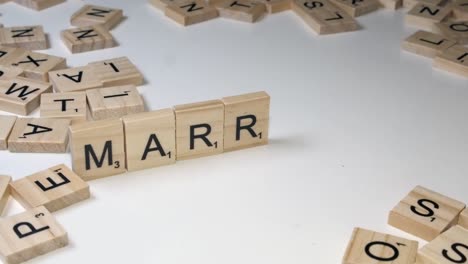 Nahaufnahme-Hand-Legt-Scrabble-Steine-Auf-Kante,-Um-Wort-Ehe-Zu-Bilden