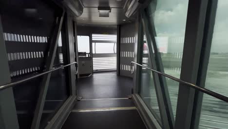 First-person-POV-walking-inside-empty-passenger-boarding-bridge-without-airplane-at-the-end