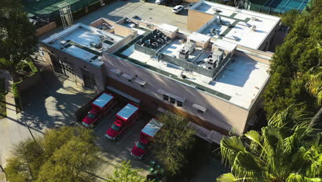 Aerial-view-around-fire-department-ambulances,-at-a-LAFD-station-in-sunny-Los-Angeles,-USA