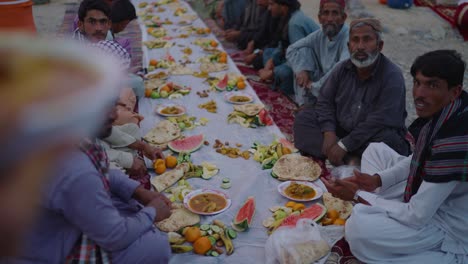 Reihe-Von-Einheimischen-Sitzen-Draußen-Neben-Essen-Während-Der-Ramadan-Iftar-Fahrt-In-Khuzdar-Belutschistan