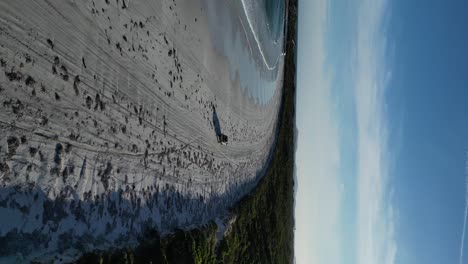 Disparo-Vertical-De-Un-Dron-Conduciendo-Un-Coche-En-Una-Playa-De-Arena-A-Lo-Largo-De-La-Costa-De-La-Costa-Australiana