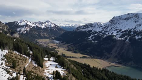 Captured-from-above,-Tirol-Tannheimer-Tal-unveils-its-snow-draped-mountain-peaks-and-a-tranquil-lake-nestled-below,-showcasing-the-serene-Swiss-landscape