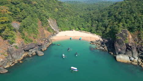 Vista-Aérea-De-La-Playa-Secreta-De-Mariposas-En-Goa,-India-Con-Bahía-Rocosa-Y-Barcos