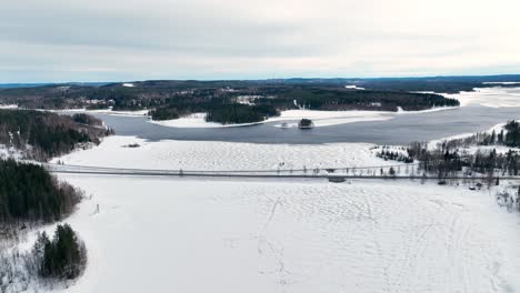 Flug-über-Einen-Zugefrorenen-See-Mit-Einer-Brücke