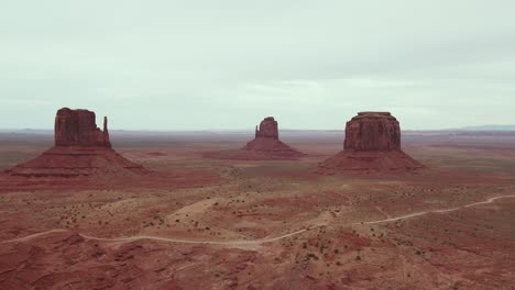 A-spectacular-4K-drone-shot-of-the-towering-Mittens-and-Merrick-Buttes-in-the-Oljato-Monument-Valley,-part-of-the-Navajo-Nation-and-located-on-the-Arizona-side-of-the-Arizona-Utah-border,-USA