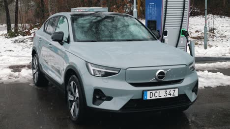 Volvo-C40-at-Charging-Station-in-Winter-Snow,-Landvetter,-Sweden