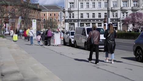 Slow-Motion-Shot-Of-Tourists-Walking-On-Pavement-Near-Historical-Buildings-In-Vienna,-Austria