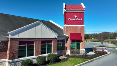 Aerial-approaching-shot-of-Peoples-Bank-Building-with-red-bricks