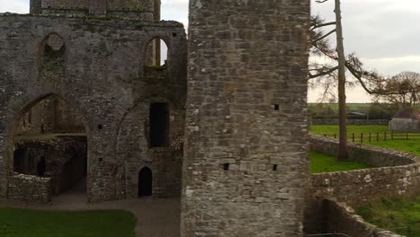 Dynamic-tracking-shot-reveals-Bective-Abbey-towers,-windows-and-doors