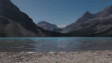 Las-Tranquilas-Aguas-De-Un-Lago-De-Montaña-Reflejan-Los-Escarpados-Picos-Circundantes-Bajo-Un-Cielo-Despejado