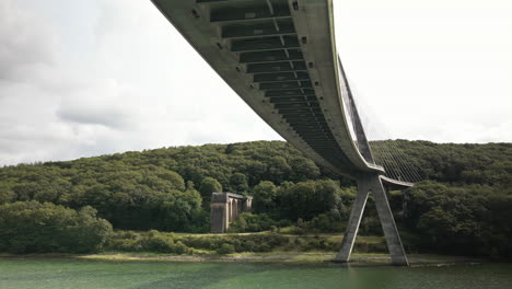 Lateral-Arc-Under-a-Large-Suspension-Bridge-Over-Body-of-Water-Seen-from-Under