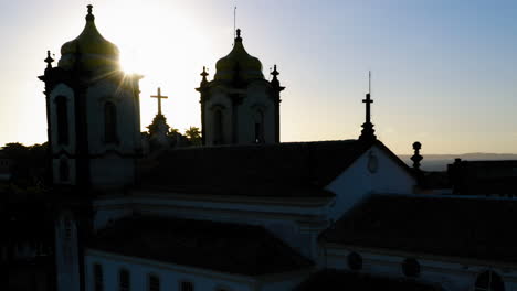 Aerial-view-of-Nosso-Senhor-do-Bonfim-church-back-side,-the-neighbourhood-and-the-ocean-at-background,-at-sunset,-Salvador,-Bahia,-Brazil